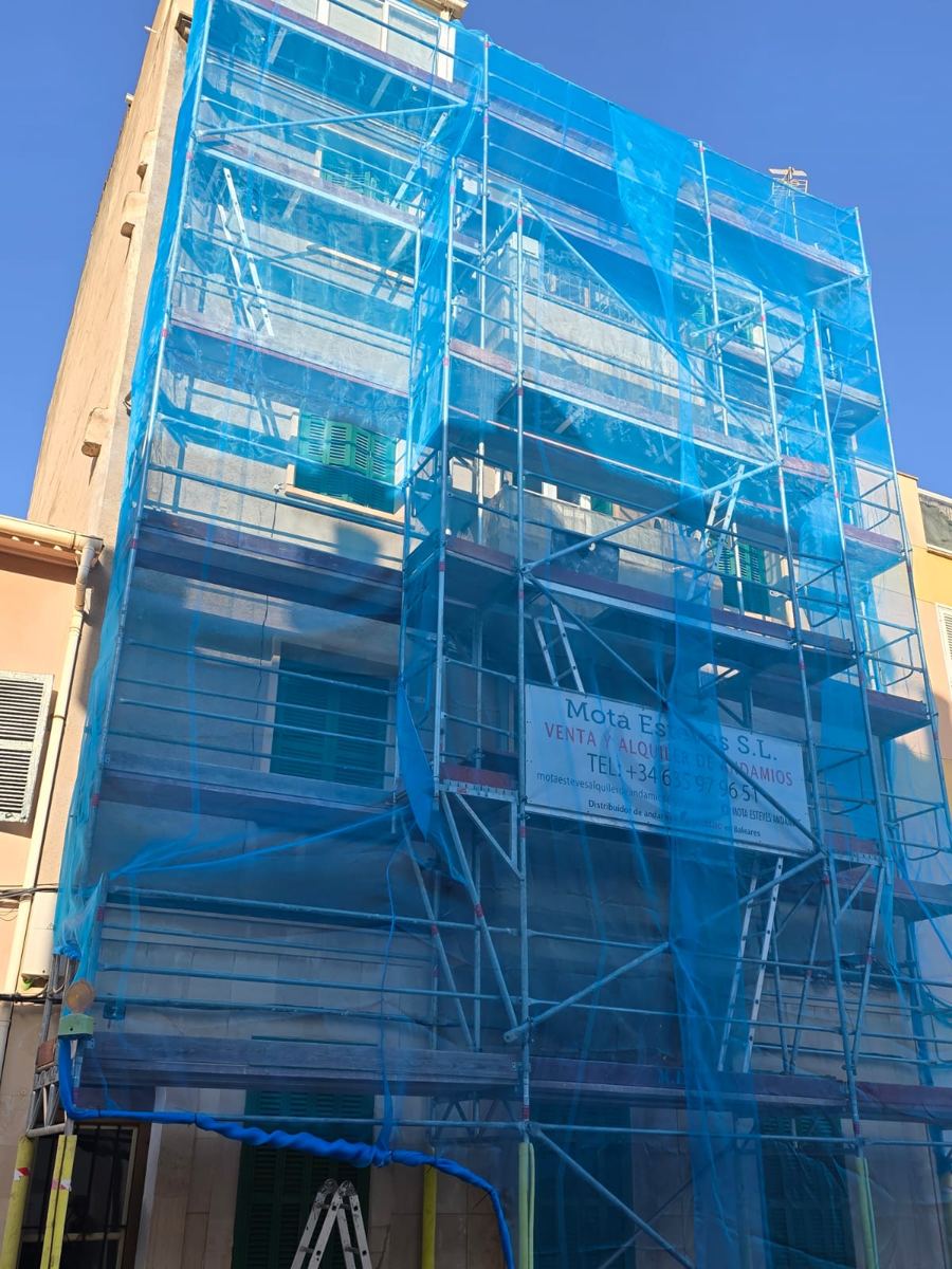 Andamio de Mota Esteves con cartel de la empresa en una fachada