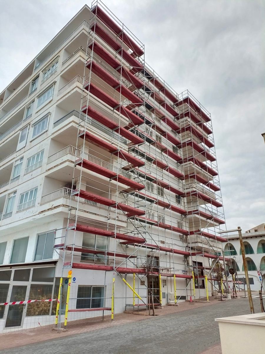 Edificio de ocho plantas con andamio de plataformas rojas