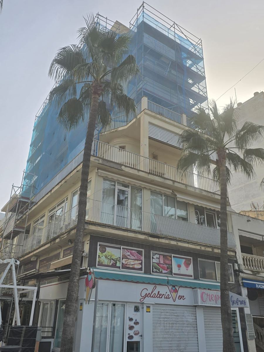 Edificio esquinero con andamio y red