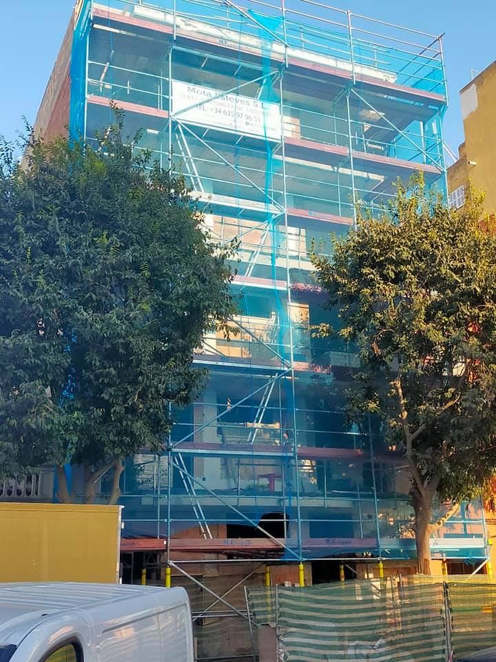 Obra nueva con andamio y red azul